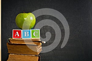 ABC and green apple on old textbook