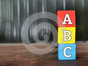 ABC letters alphabet on colorful wooden blocks with blurry background and copy space.