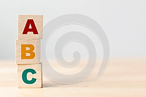 ABC letters alphabet on wooden cube blocks in pillar form on wood table