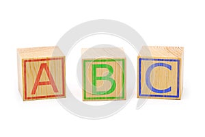 ABC letters on three brown wooden cubes lined up