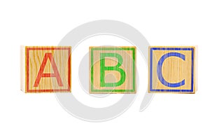 ABC letters on three brown wooden cubes lined up