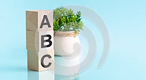 ABC letters of wooden blocks in pillar form on blue background, copy space