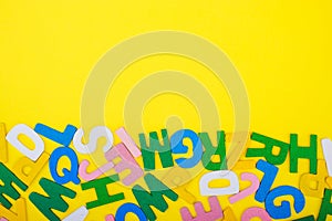 ABC wooden letters alphabet scattered on a yellow background