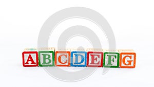 ABCDEFG wooden letter blocks isolated on white background