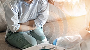 Abdominal pain patient woman having medical exam with doctor on illness from stomach cancer, irritable bowel syndrome photo