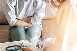 Abdominal pain patient woman having medical exam with doctor on illness from stomach cancer, irritable bowel syndrome photo