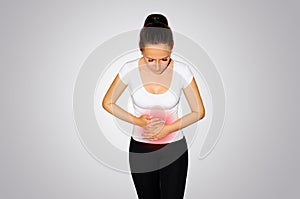 Abdominal pain. A young woman suffers from pain in the abdomen. The problem with digestion. The problem of women`s health, the co