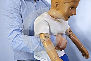 Abdominal thrusts the Heimlich maneuver or Heimlich manoeuvre on a simulation mannequin child dummy during medical training