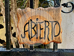 ABIERTO sign, the Spanish word for OPE, into a wooden board. photo