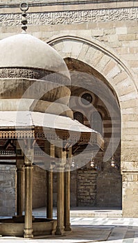 Ablution fountain at historic Sultan Barquq Mosque with huge arch in background, Cairo, Egypt