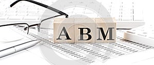 ABM text on a wooden block on chart background