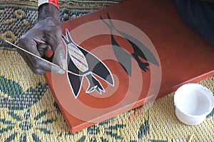 Aboriginal artist creating a dot painting photo