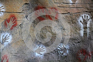 Aborigine art hands on stone wall
