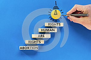 Abortion rights symbol. Concept words Abortion rights are human rights on wooden blocks. Businessman hand. Beautiful blue table