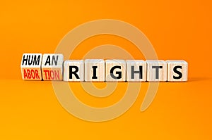 Abortion rights symbol. Concept words Abortion rights are human rights on wooden cubes. Beautiful orange table orange background.