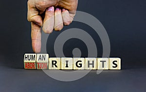 Abortion rights symbol. Concept words Abortion rights are human rights on wooden cubes. Businessman hand. Beautiful grey table