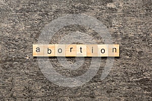 abortion word written on wood block. abortion text on table, concept