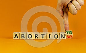 Abortion yes or no symbol. Doctor turns a cubes and changes words `abortion yes` to `abortion no` or vice versa. Beautiful ora