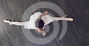 Above, ballet and portrait of dancer on the floor in splits with legs, dancing and stretching in class or studio