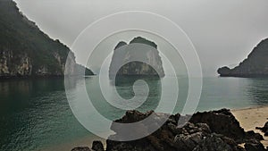 Above the calm water of Halong Bay, quaint islands rise