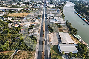 Above of car driving on highway road with local village and commercial building in suburban