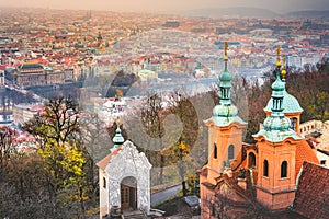 Above church of St. Lawrence and Prague old town towers and domes at dusk, Czech