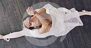 Above, dancer and portrait of ballet on the floor in splits with legs, dancing and stretching in class or studio