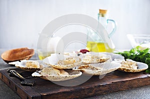 From above fresh appetizing scallop with shell served on wooden boars