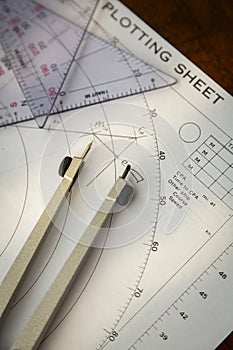 Above image of a navigator's radar plotting chart with a triangle and compass divider