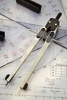 Above image of a navigator's radar plotting chart with a triangle and compass divider