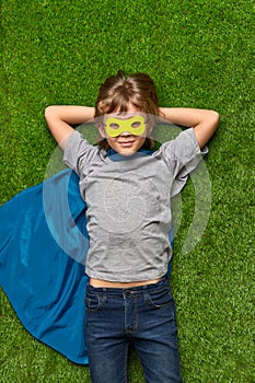 Confident superhero lying on lawn