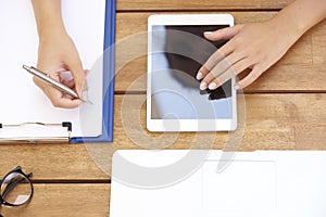 From above shot of woman`s hand touching digital tablet and writ