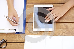 From above shot of woman`s hand touching digital tablet and writ