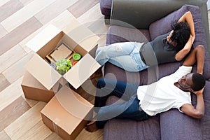 Above view african couple resting on couch on moving day