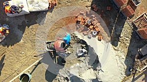 Above view on building site, builder is using shovel to throws Ingredients to prepare mortar