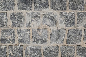 From above, a view of the cobblestone street . The texture of the stone pavement. Granite stones.