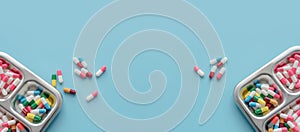 Above view of Colorful antibiotic capsule pills on tray and blue background. Antibiotic drug resistance. Antimicrobial drugs.