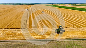 Above view on combine, tractor waits for transshipment as harvester harvest wheat