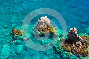 Above view of couple snorkeling in turquoise sea water, Glyka Nera, Chania, Crete.