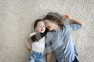 Above view cute little girl lying on carpet with mother