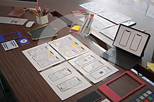 Digital tablet and website wireframe for mobile application on wooden table.