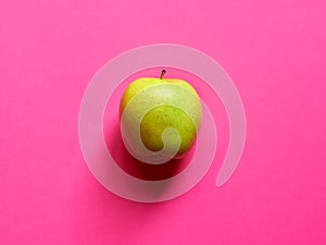 Above view of a Green apple isolated in a pastel fuscia background