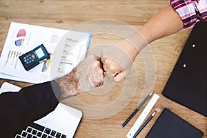 Above view hands of businessmen doing fists bump after agreed to be corperate partner