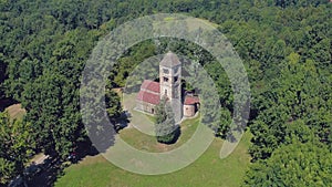 above view of isolated old catholic christian romanesque church with bell tower in nature outdoor scene 4k aerial drone