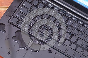 Above view of laptop with water drop damage liquid wet and spill on keyboard, accident concept