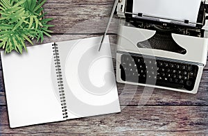 above view of old typewriter and spiral notepad on rustic wooden desk