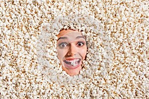 Above view photo of cheerful astonished overjoyed girl face buried isolated on background with full popcorn