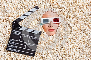 Above view photo of lady face 3d glasses clap board buried isolated on on background with full popcorn