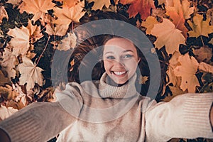 Above view photo of lovely positive girl laying fallen leaves take selfie toothy smile enjoy pastime outside