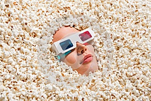 Above view portrait of young person watch movie 3d glasses face buried creative full with popcorn background